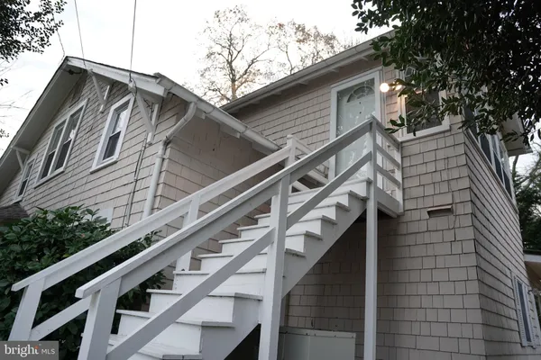 a view of wooden house with a large tree