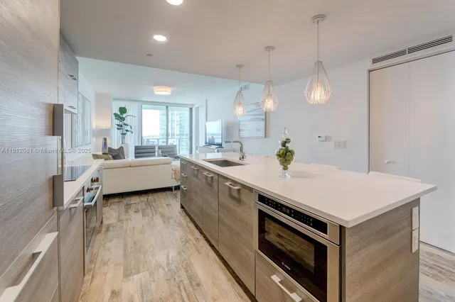 a kitchen with a stove a refrigerator a sink and wooden floor