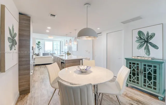 a dining room with furniture a chandelier and wooden floor