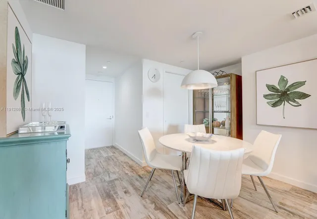 a view of a dining room with furniture a kitchen and chandelier