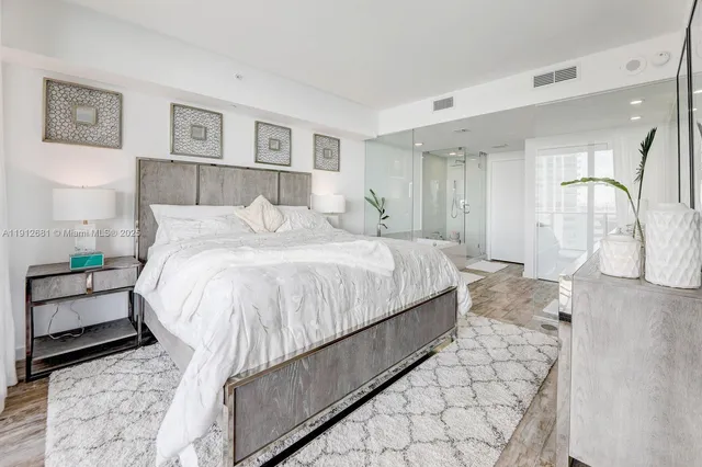 a large bed sitting in a bedroom next to a window