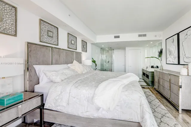 a bedroom with a large bed and a painting on the wall