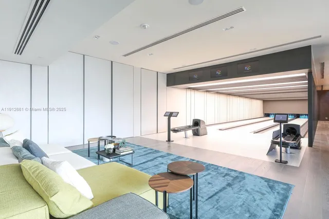 a living room with couches and kitchen view with wooden floor