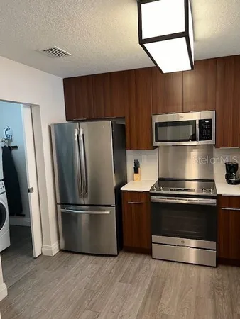 a kitchen with wooden floors and stainless steel appliances