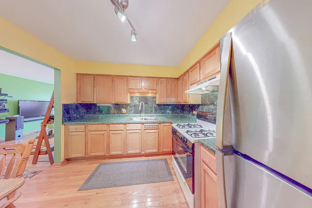 a kitchen with stainless steel appliances granite countertop a refrigerator and a stove