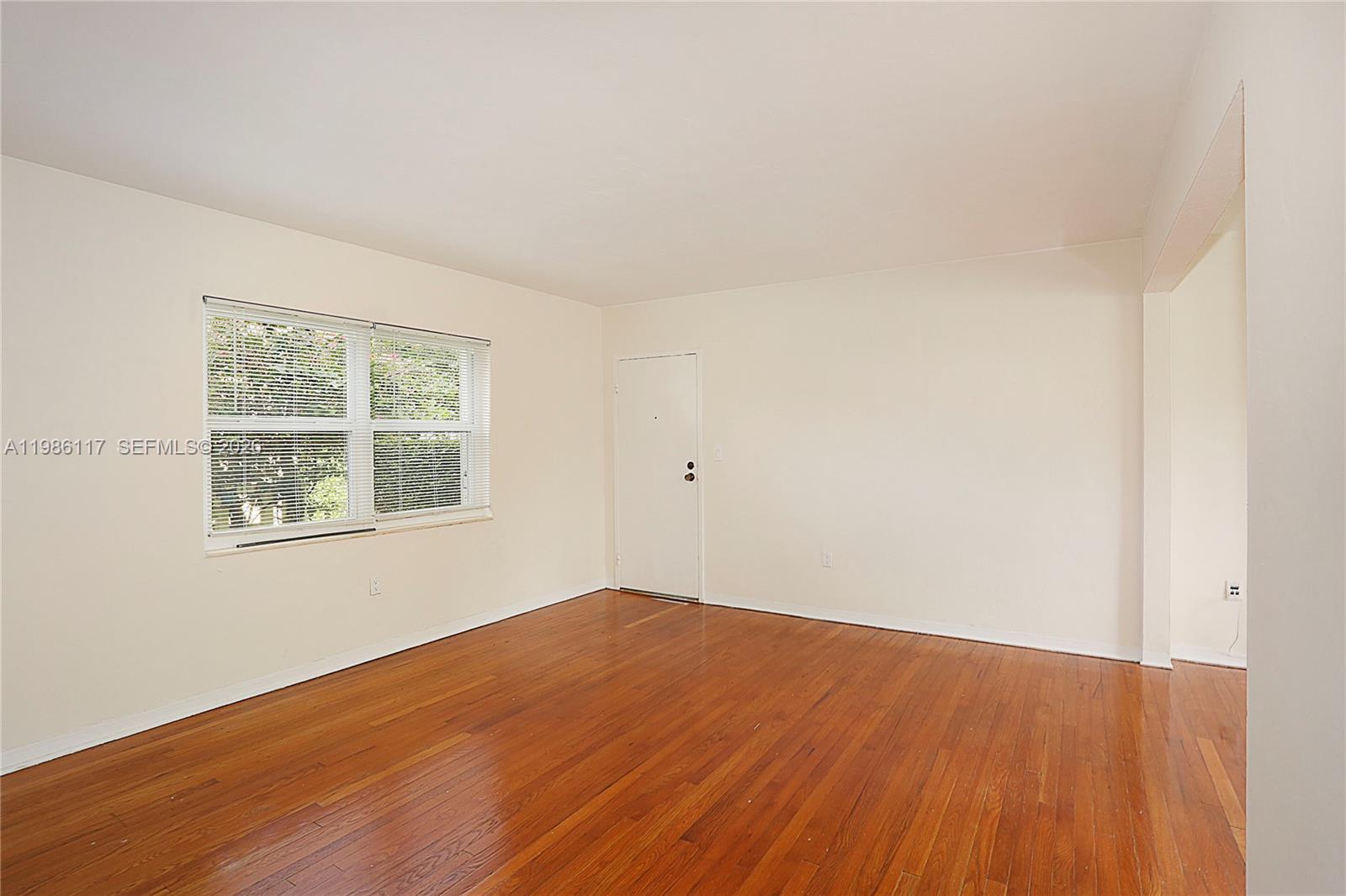 7720 Southwest 54th Court, Unit 42B Miami, FL 33143 - Photo 2 of 6 an empty room with wooden floor and windows