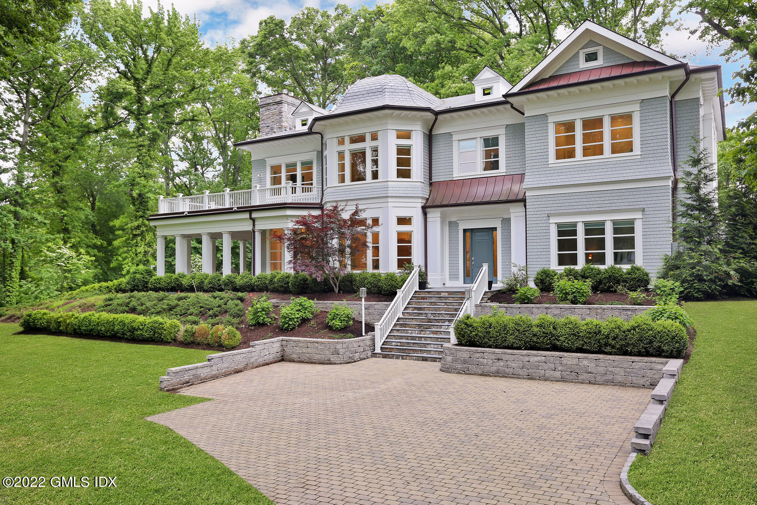 a front view of a house with a yard and green space