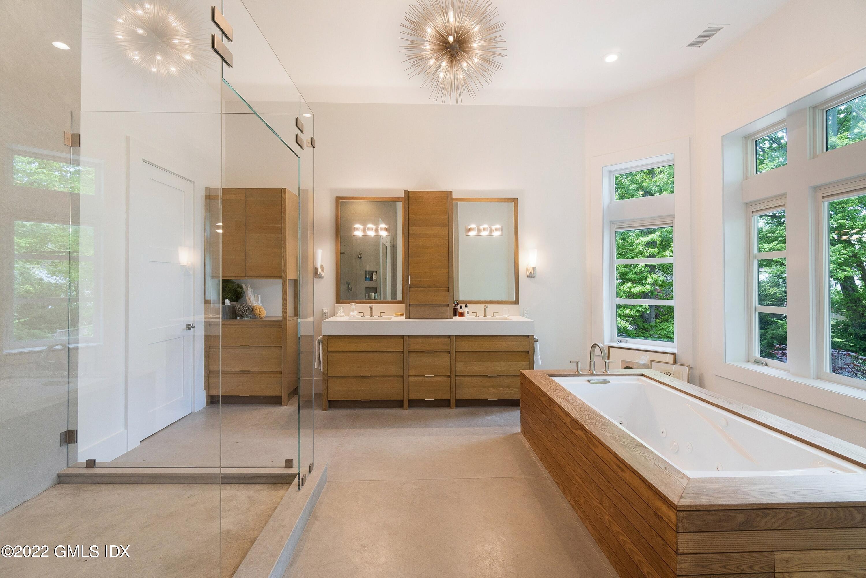 22 Oak Drive Riverside, CT 06878 - Photo 18 of 40 a bathroom with a tub a double vanity sink and a large mirror