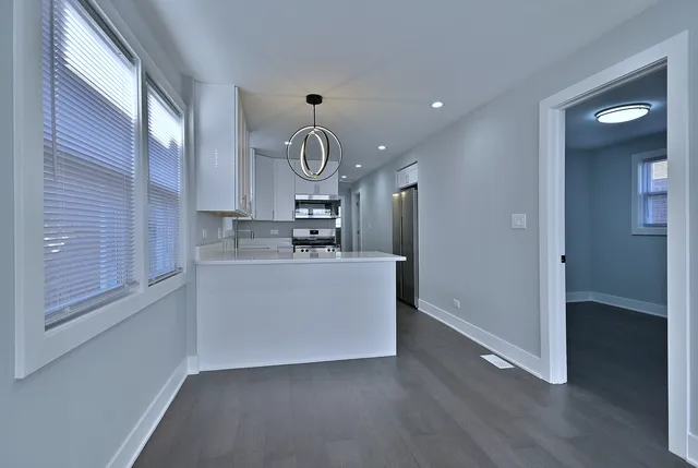 a view of kitchen with cabinets and window