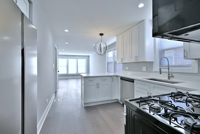 a kitchen with white cabinets and appliances