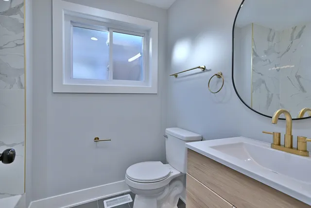 a bathroom with a toilet sink and mirror
