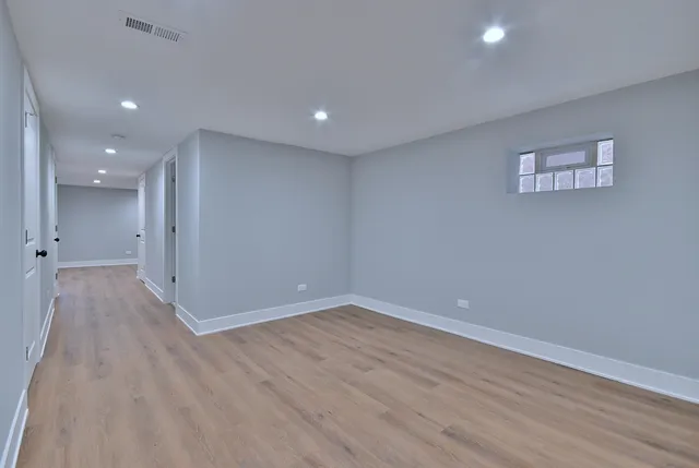 a view of an empty room with wooden floor