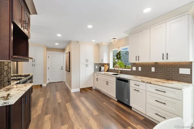 a kitchen with granite countertop white cabinets and white appliances