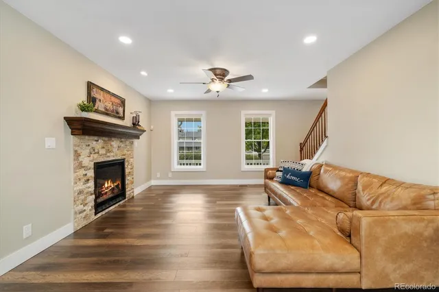 a living room with furniture a fireplace and a large window