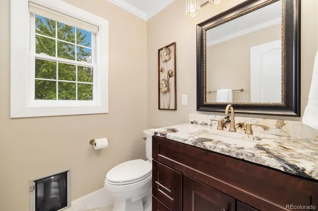 a bathroom with a granite countertop toilet a sink and a mirror
