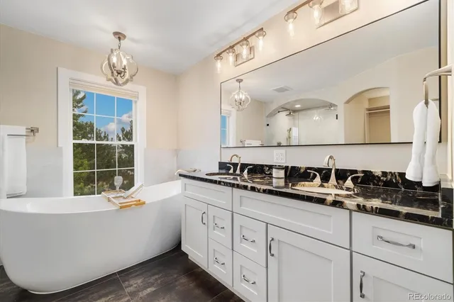 a bathroom with a double vanity sink a mirror and a bathtub