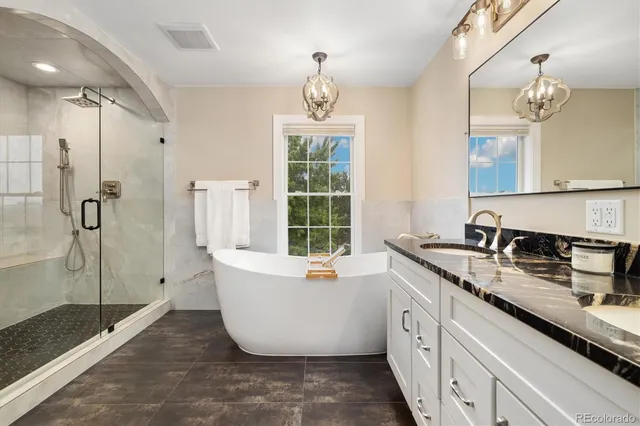 a spacious bathroom with a granite countertop tub sink and mirror