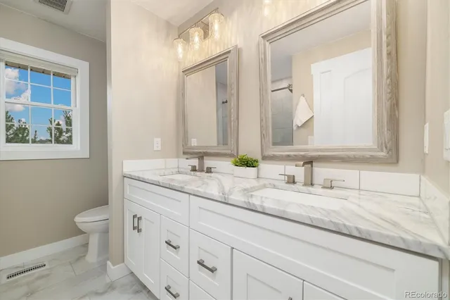 a bathroom with mirror sink and toilet