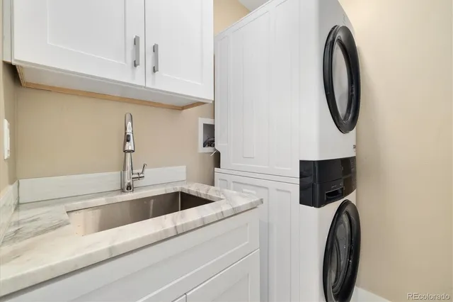 a kitchen with granite countertop a sink a stove and cabinets
