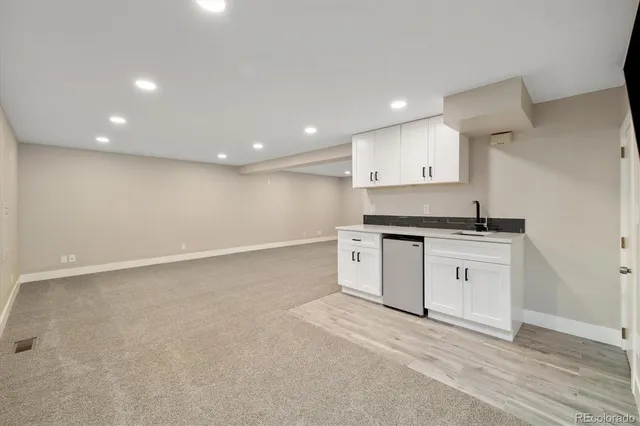 a view of an empty room with cabinet and mirrors