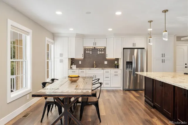 a kitchen with a table chairs refrigerator and microwave
