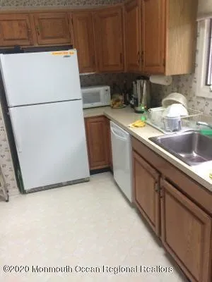 a kitchen with a refrigerator a sink a stove and white cabinets