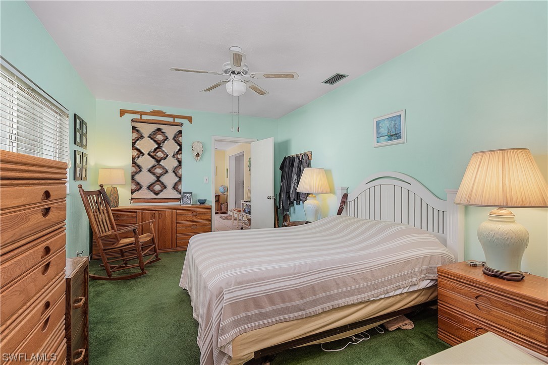 5776 Tarpon Road Bokeelia, FL 33922 - Photo 23 of 31 a bedroom with a bed and a chandelier