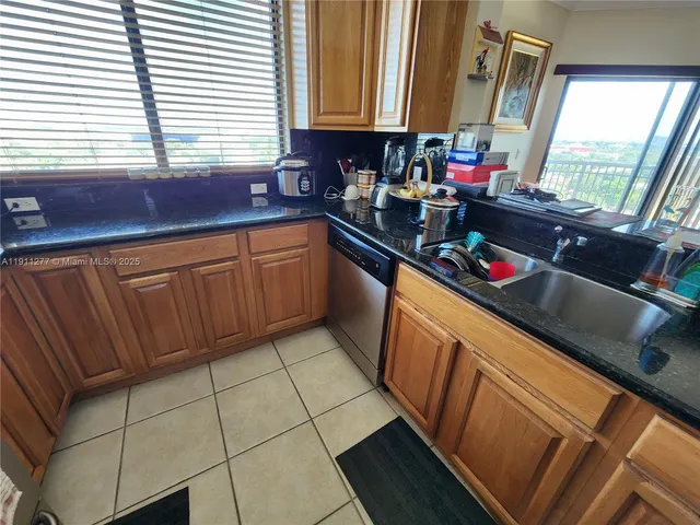 a kitchen with stainless steel appliances a sink dishwasher window and cabinets
