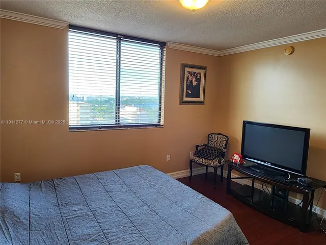 a bedroom with a bed and a flat screen tv