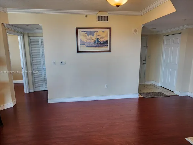 an empty room with wooden floor and a window