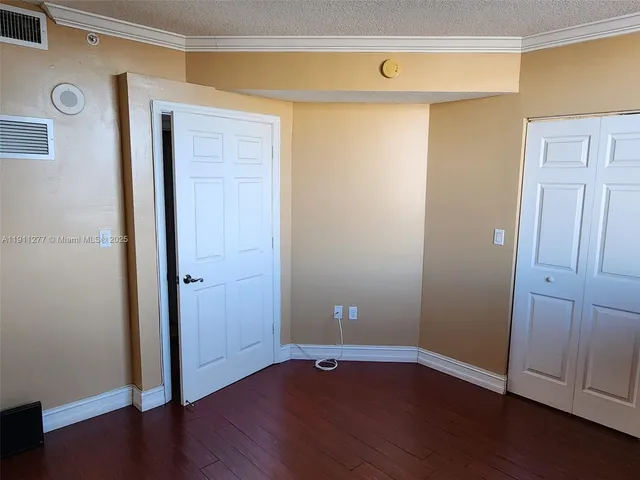 an empty room with wooden floor and closet