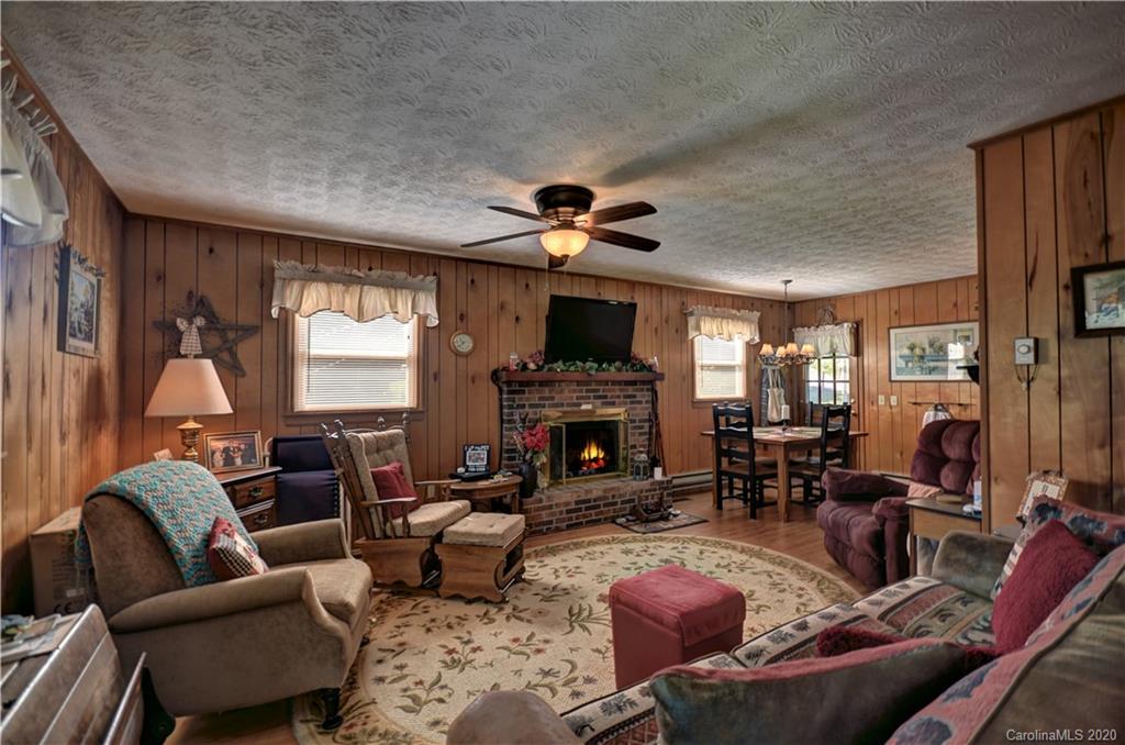 238 Raven Ridge Maggie Valley, NC 28751 - Photo 8 of 21 a living room with furniture a fireplace and a chandelier