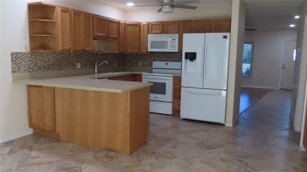 2291 Americus Boulevard West, Unit 7 Clearwater, FL 33763 - Photo 16 of 57 a kitchen with a refrigerator sink and cabinets