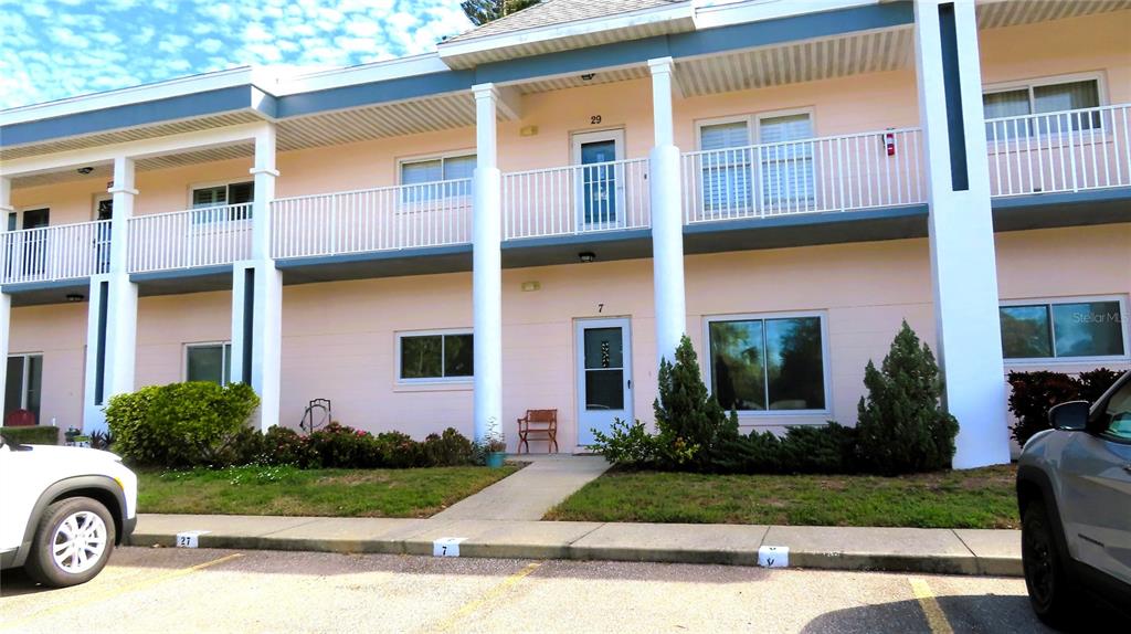 2291 Americus Boulevard West, Unit 7 Clearwater, FL 33763 - Photo 2 of 57 a front view of a house with a garden