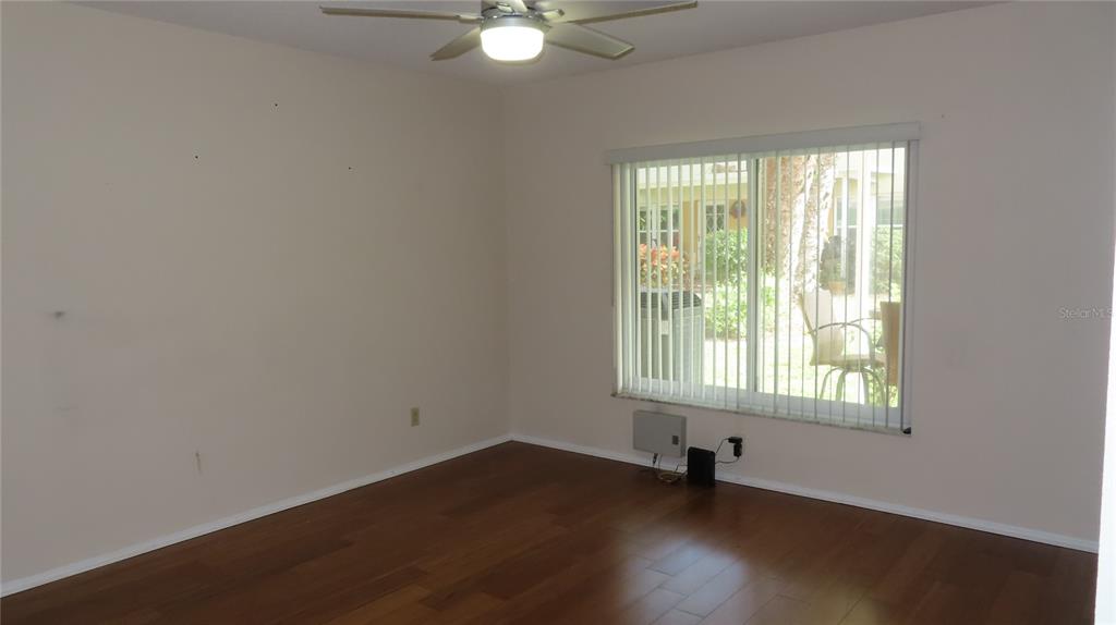 2291 Americus Boulevard West, Unit 7 Clearwater, FL 33763 - Photo 25 of 57 an empty room with wooden floor and windows
