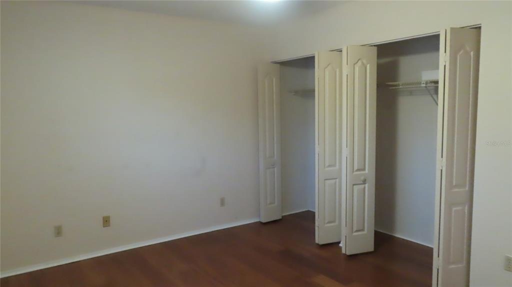 2291 Americus Boulevard West, Unit 7 Clearwater, FL 33763 - Photo 37 of 57 an empty room with wooden floor and windows