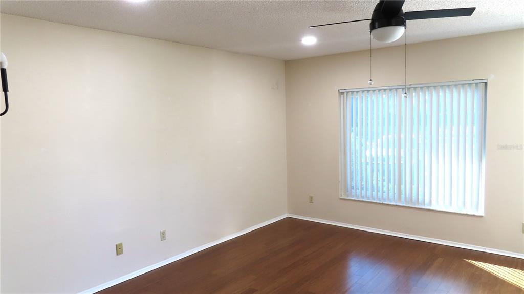 2291 Americus Boulevard West, Unit 7 Clearwater, FL 33763 - Photo 9 of 57 an empty room with wooden floor and windows