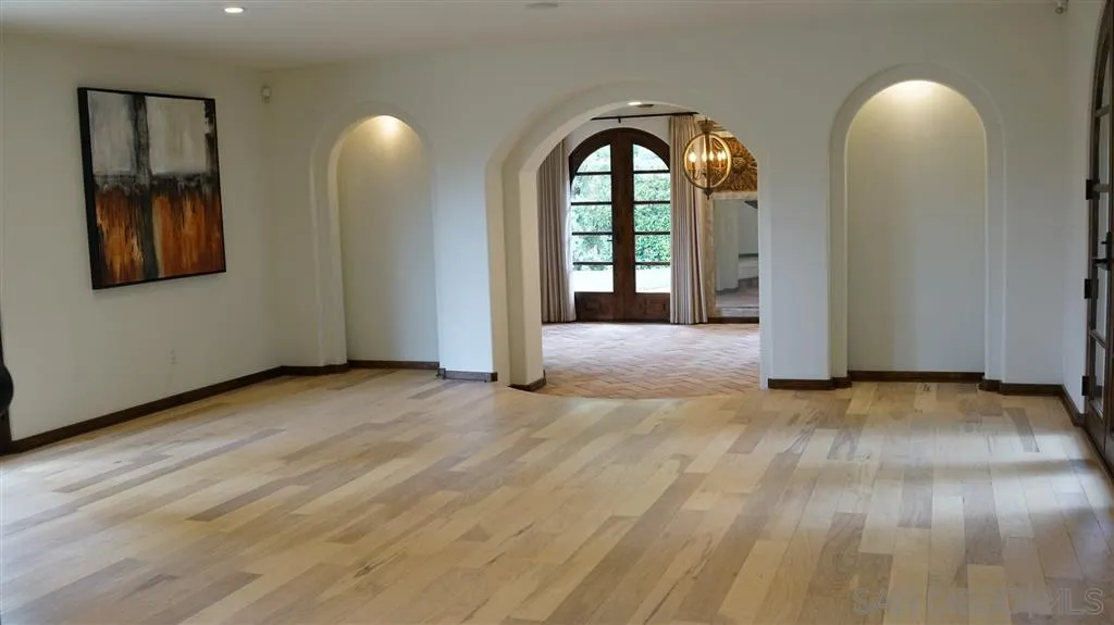 6511 Poco Lago Rancho Santa Fe, CA 92067 - Photo 5 of 24 an empty room with wooden floor and mirror