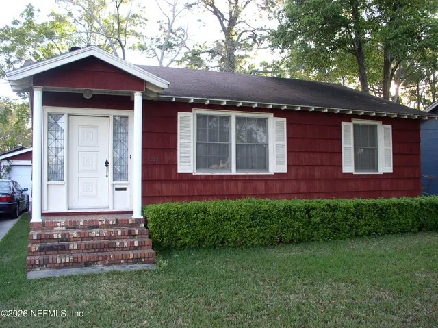 a front view of a house with a garden