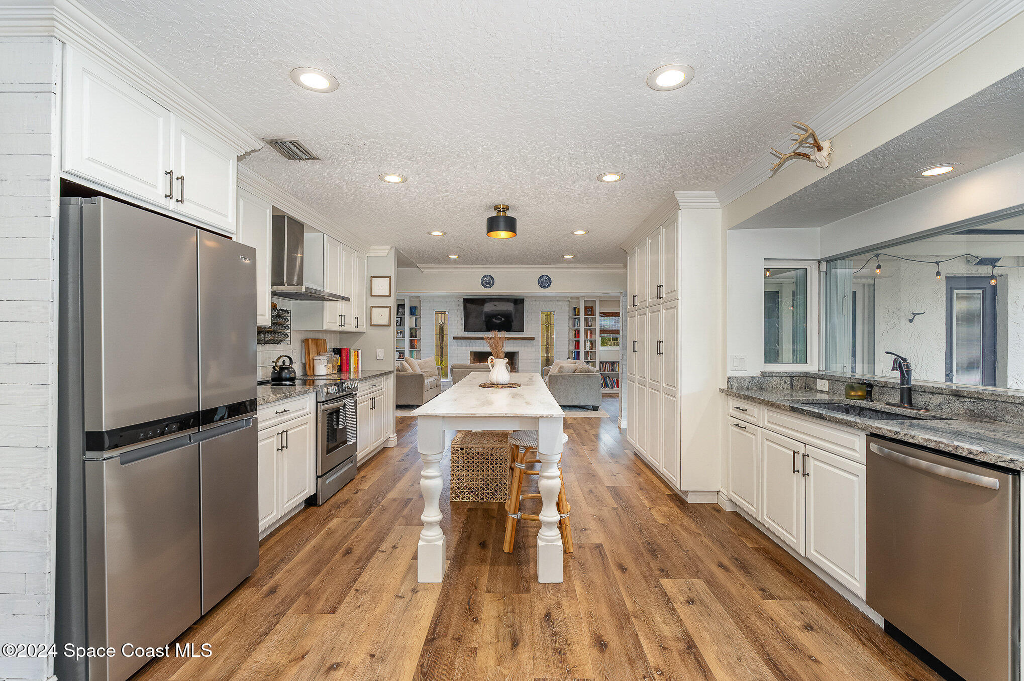 2175 Rockledge Drive Rockledge, FL 32955 - Photo 11 of 48 a white kitchen with wooden floor and stainless steel appliances
