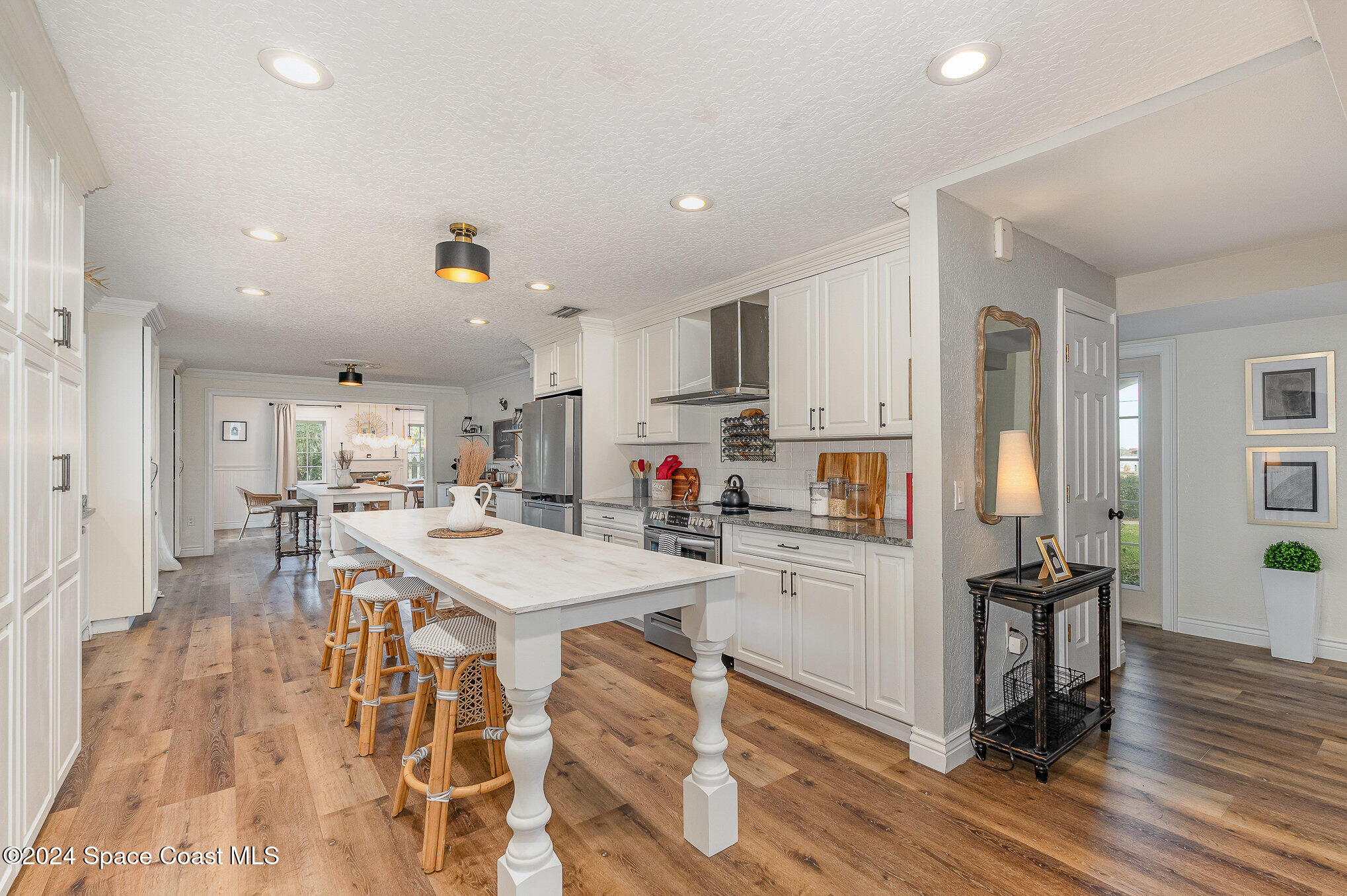 2175 Rockledge Drive Rockledge, FL 32955 - Photo 13 of 48 a kitchen with a dining table chairs refrigerator and cabinets