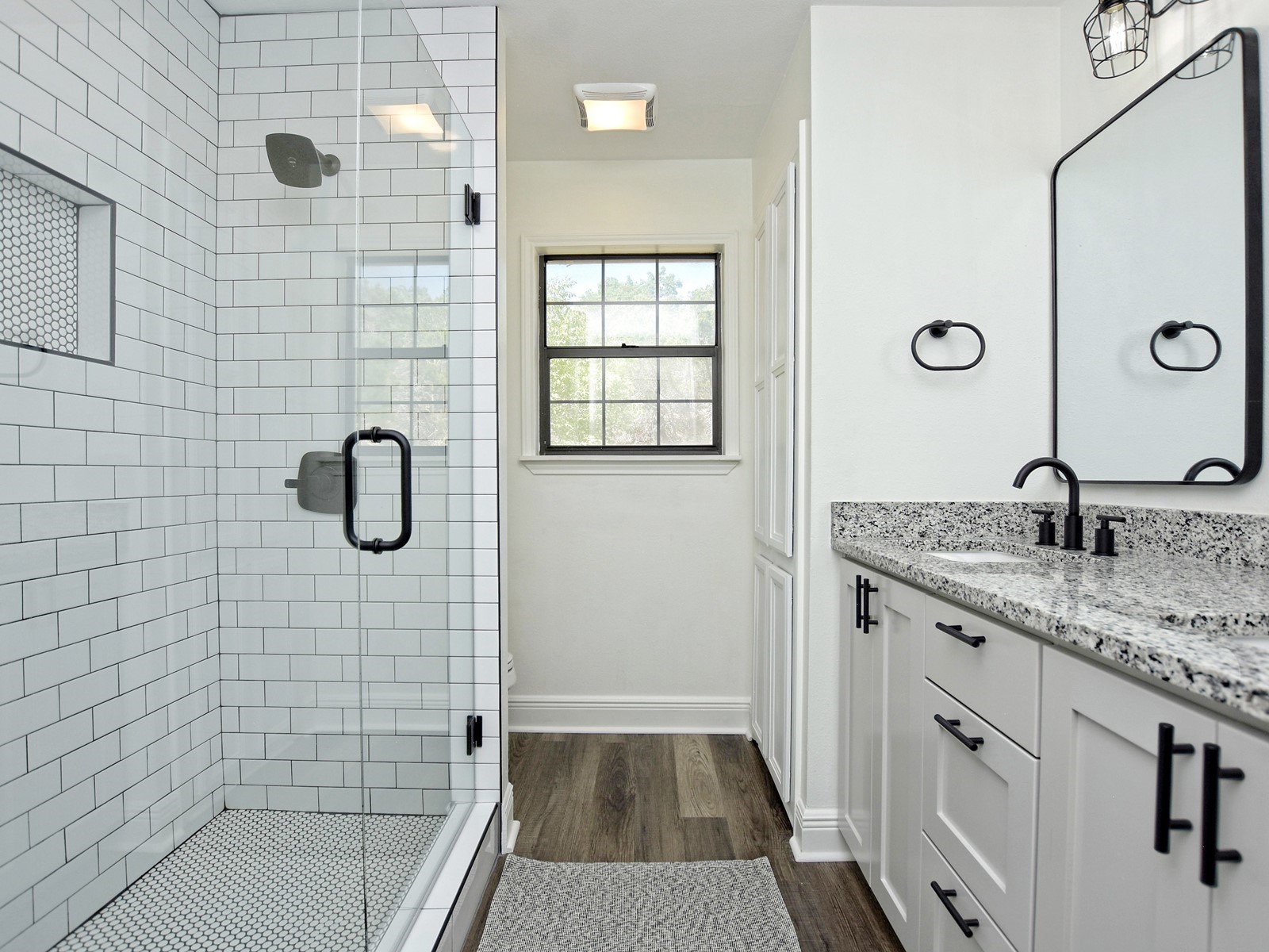 13404 Cedar Lime Road Leander, TX 78641 - Photo 18 of 28 A well-lit bathroom showcases a contemporary vanity with a granite countertop and a spacious glass-enclosed shower.