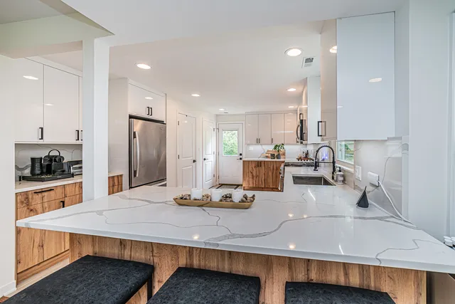 a kitchen with a table chairs refrigerator and microwave