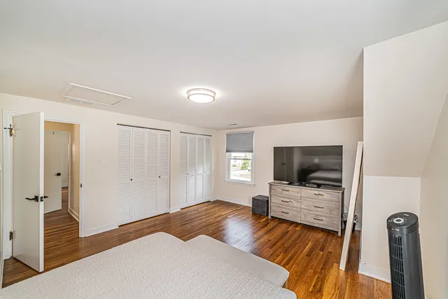 a bedroom with a bed and flat tv screen on wall