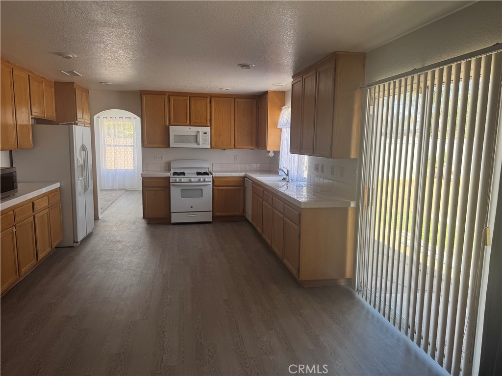 674 Myrtle Avenue Perris, CA 92571 - Photo 3 of 17 a kitchen with stainless steel appliances granite countertop a refrigerator a stove and a sink