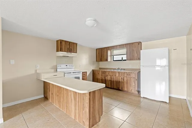a kitchen with a sink a refrigerator and a stove top oven