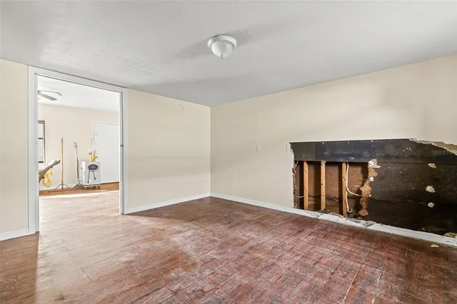 a view of a room with an empty space and wooden floor