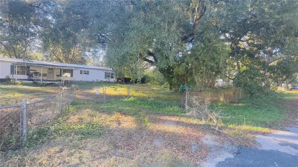 a view of swimming pool with a yard and large trees