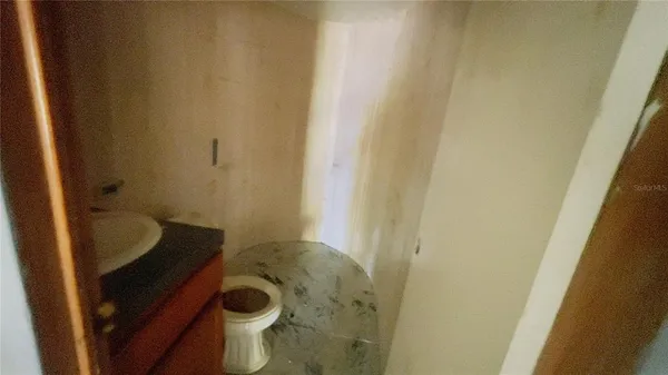 a bathroom with a granite countertop toilet and a sink