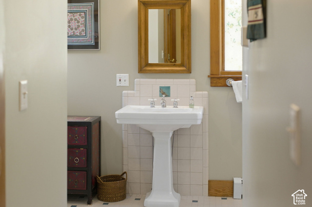 725 Canyon Road Smithfield, UT 84335 - Photo 56 of 100 Pedestal sink with white tile backsplash, wood-framed mirror, and wood-framed window